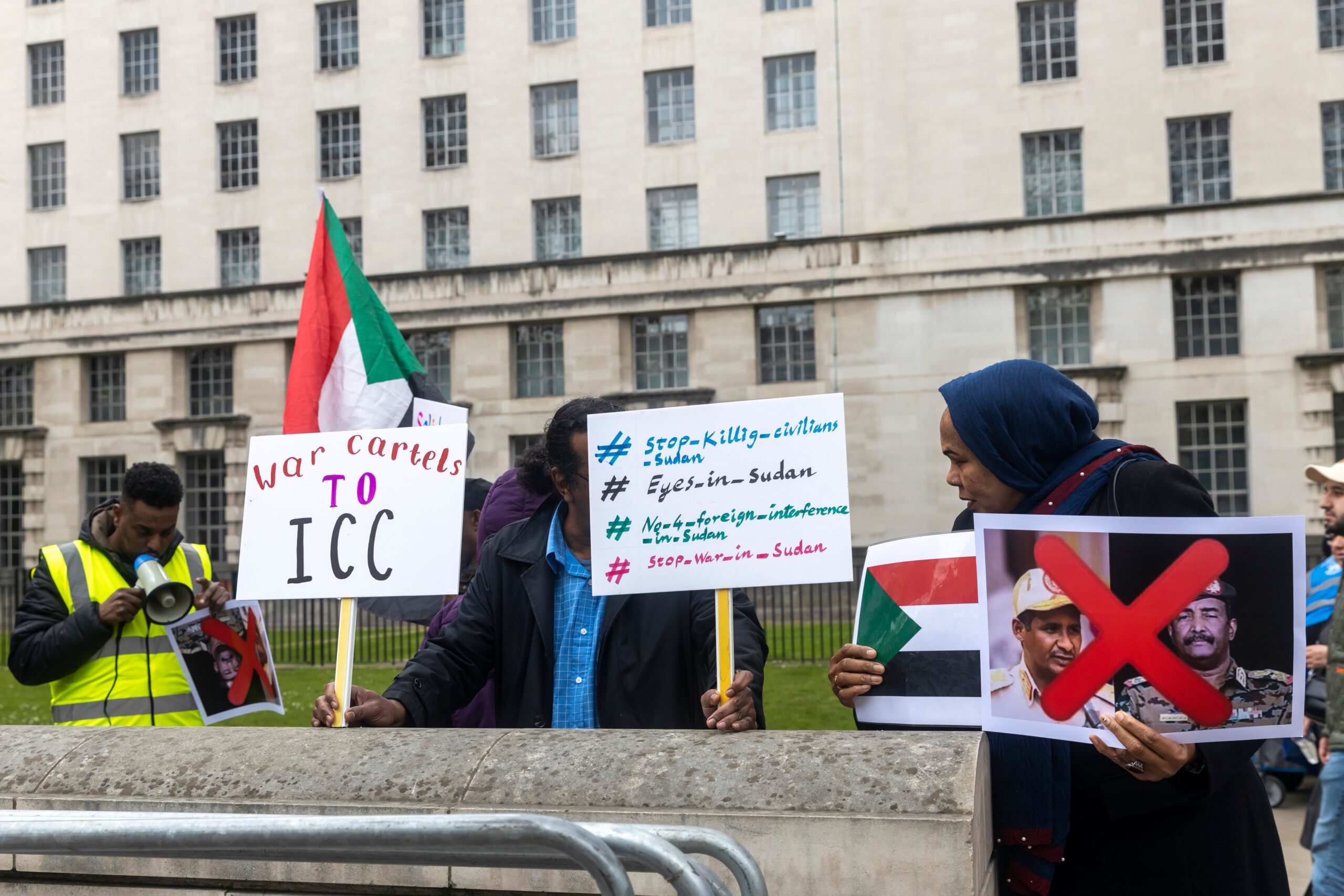 protesters holding signs to stop war in Sudan